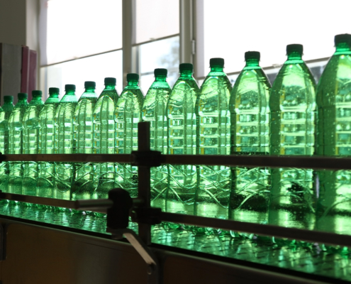 Green bottles being packaged in manufacturing facility