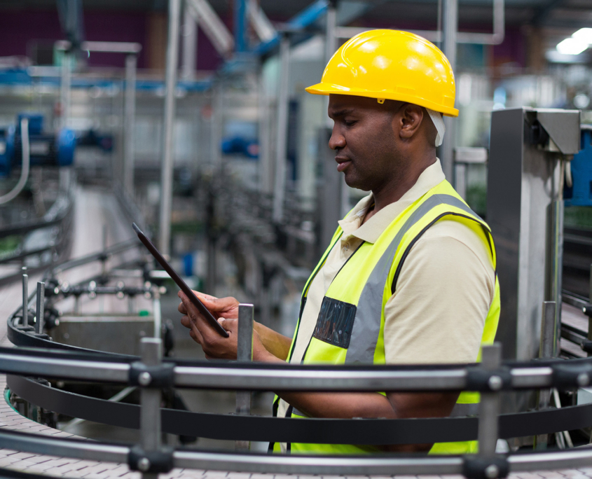 Factory worker using a digital tablet near the production line